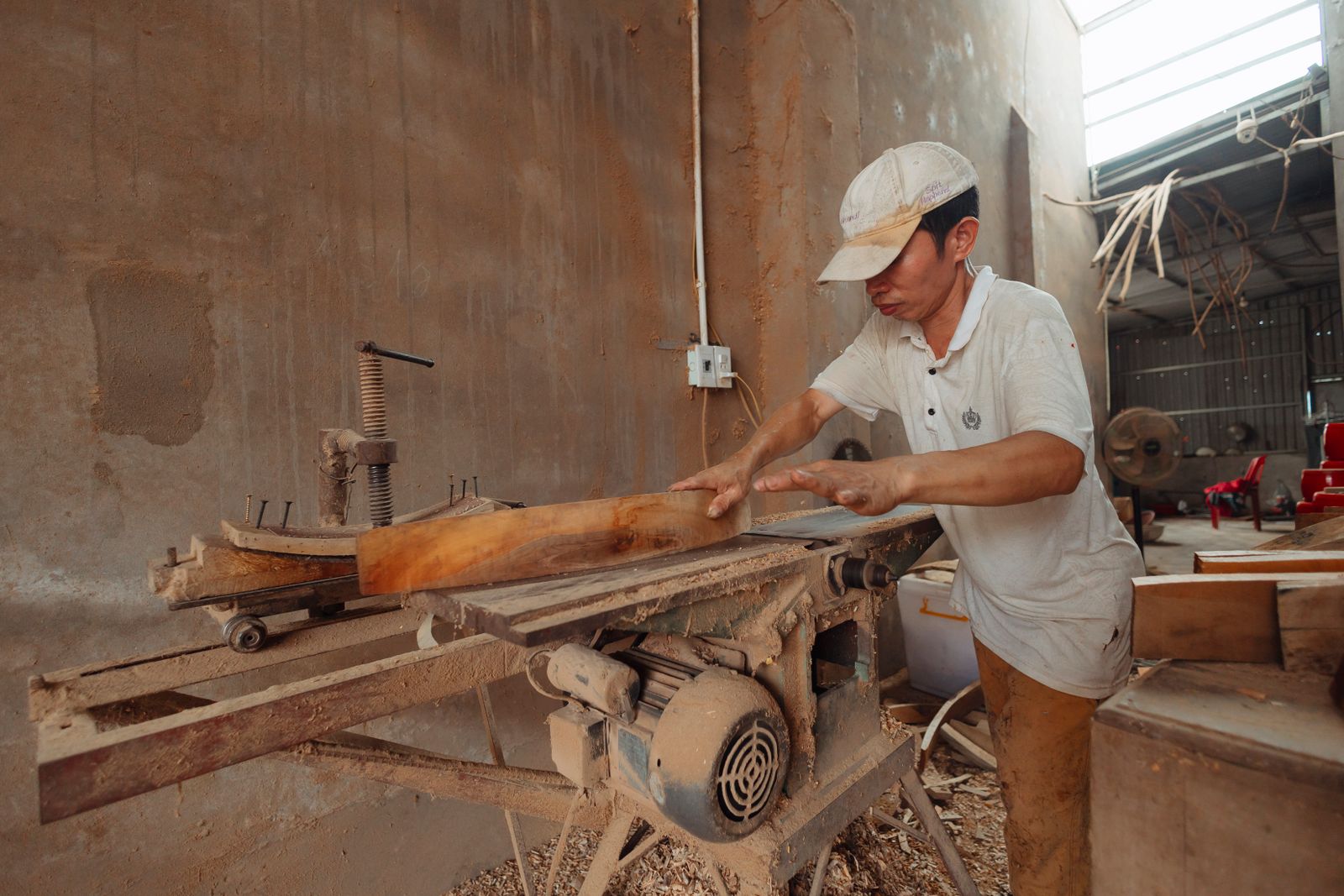 A carpenter cutting timber in the atelier workshop